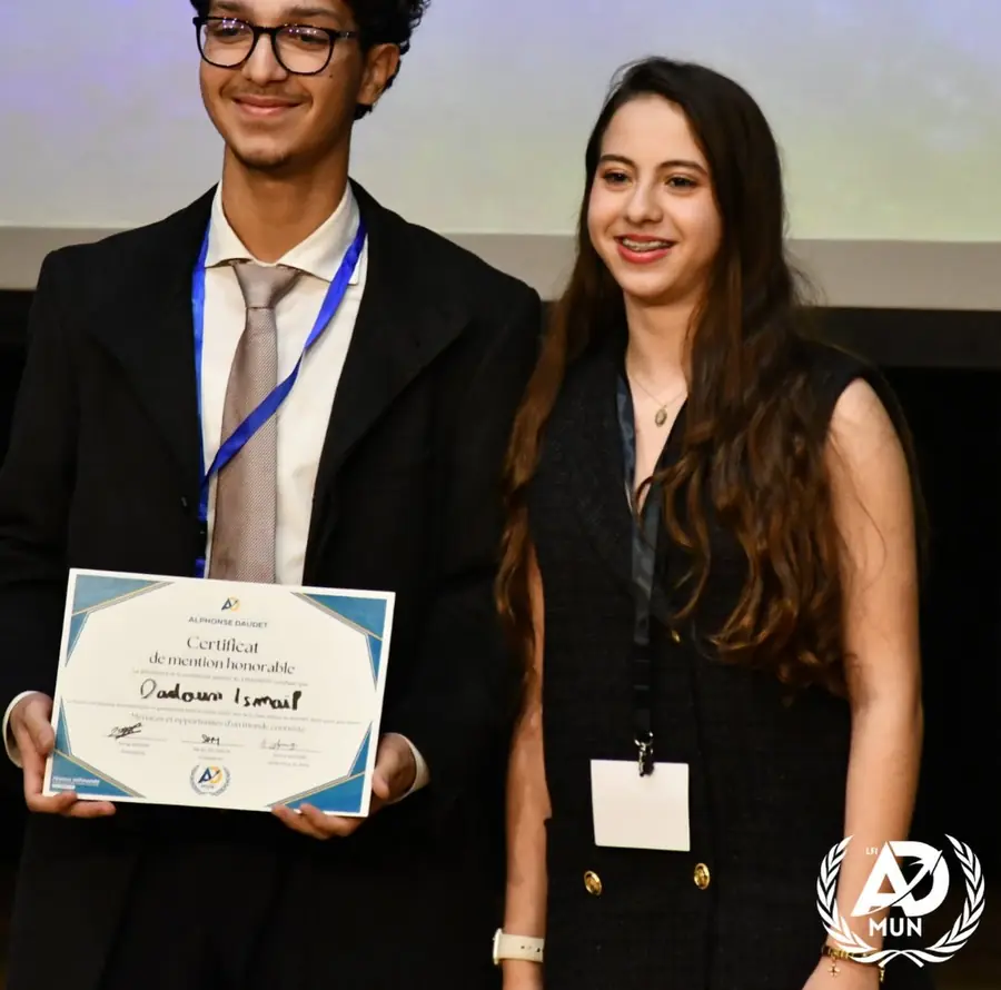 Un délégué et une déléguée sourient, un certificat de mention honorable à la main