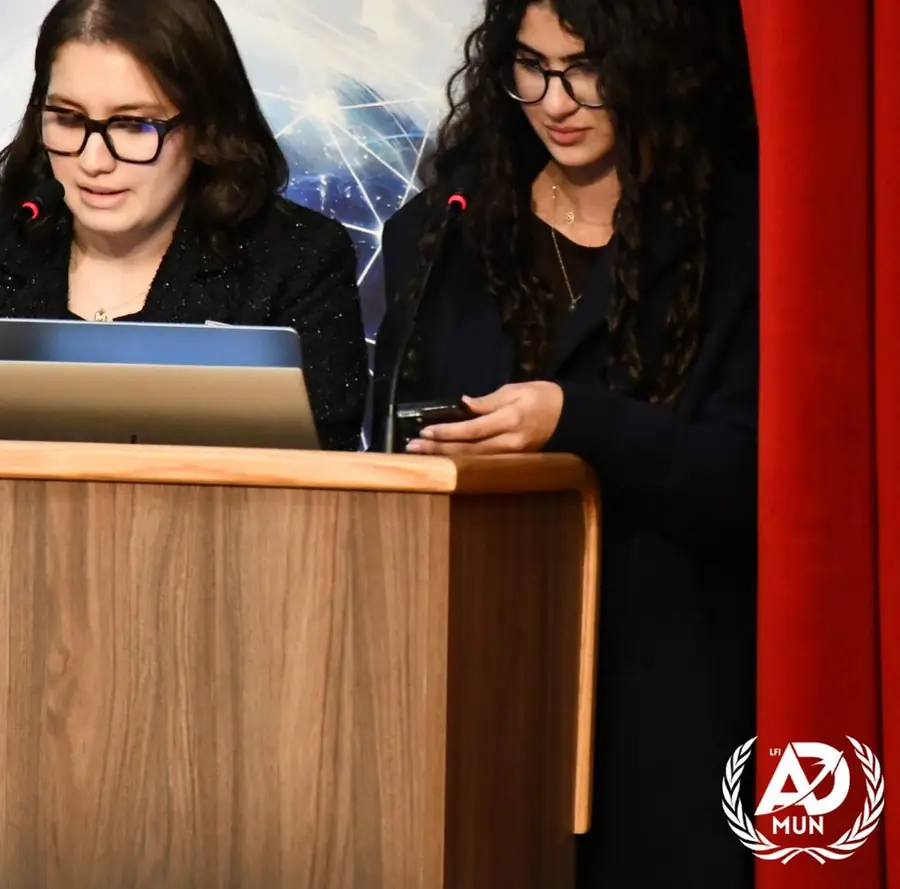 Deux déléguées lisent leur intervention derrière le pupitre