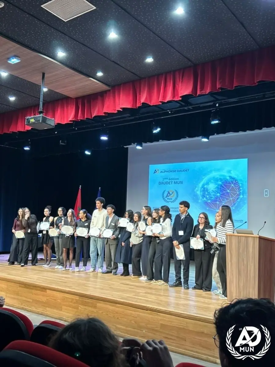 Une vingtaine de délégués alignés sur scène, certificats à la main, sous les projecteurs de la salle